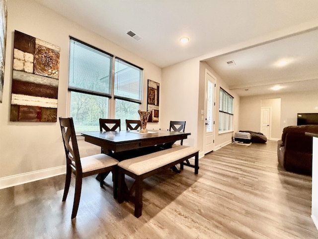 dining space with baseboards, visible vents, and wood finished floors