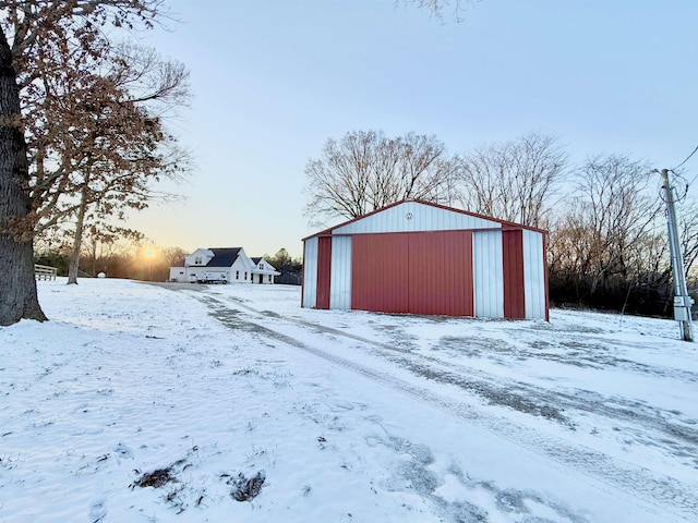 snow covered structure with an outbuilding and an outdoor structure