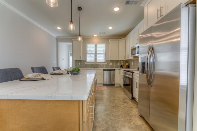 kitchen with a kitchen island, visible vents, appliances with stainless steel finishes, backsplash, and crown molding