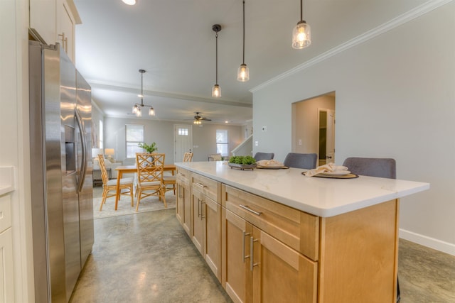 kitchen featuring finished concrete flooring, stainless steel fridge, baseboards, decorative light fixtures, and a center island