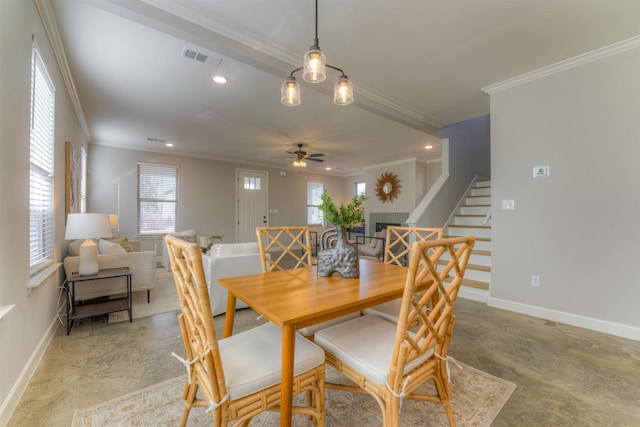 dining space with baseboards, a tiled fireplace, ornamental molding, stairs, and concrete flooring