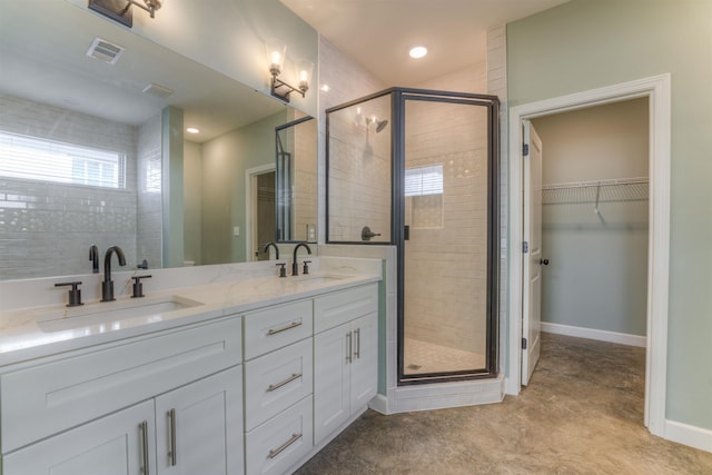 bathroom with a stall shower, visible vents, a sink, and baseboards