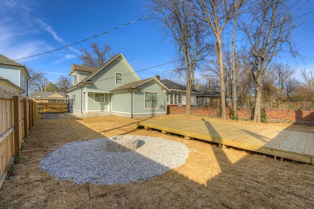 rear view of house with a fenced backyard and a wooden deck