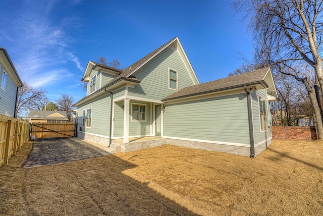 back of property featuring fence and a lawn