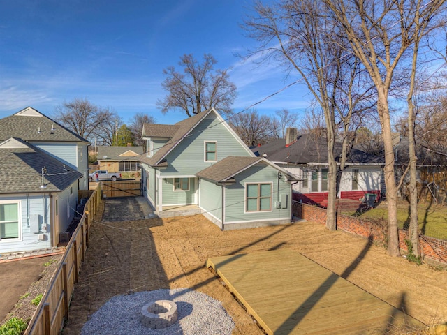 view of front of property featuring a shingled roof, fence, and driveway