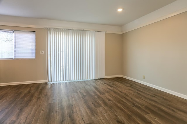 unfurnished room featuring recessed lighting, dark wood finished floors, and baseboards