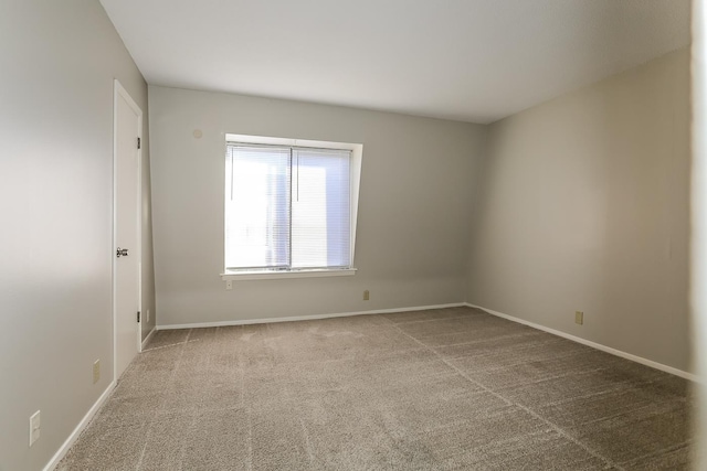 unfurnished room with carpet floors and baseboards