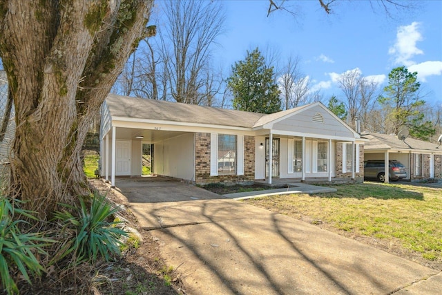 view of front of house featuring an attached carport, a porch, brick siding, concrete driveway, and a front lawn