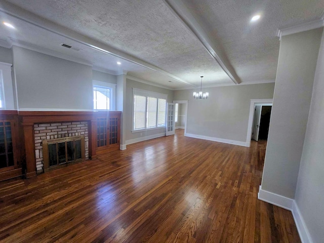 unfurnished living room with visible vents, ornamental molding, wood finished floors, a textured ceiling, and a fireplace