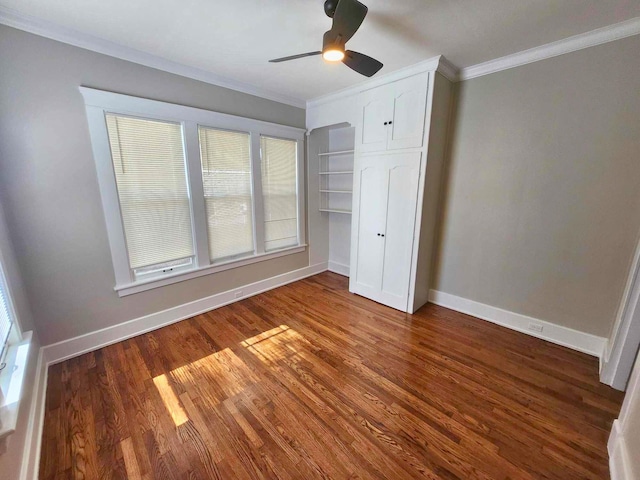 unfurnished bedroom with a closet, crown molding, baseboards, and wood finished floors