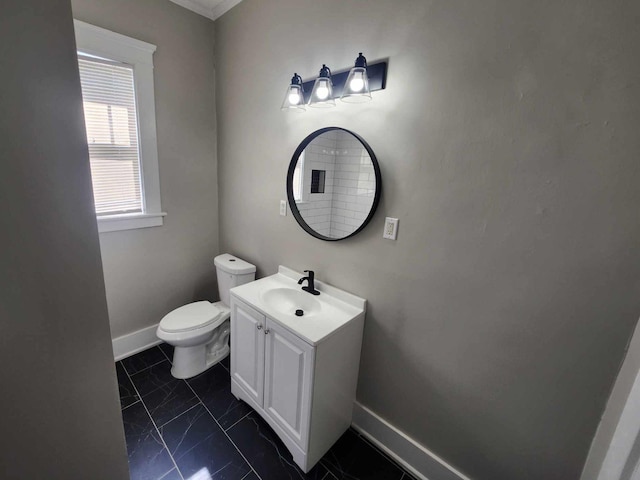 bathroom with vanity, toilet, and baseboards