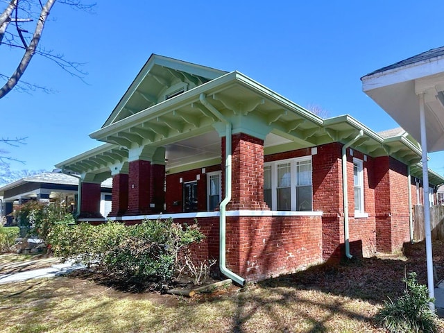 view of side of property with a porch and brick siding