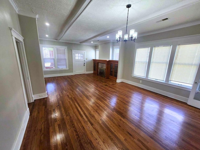 unfurnished living room with a wealth of natural light, a textured ceiling, baseboards, and wood finished floors