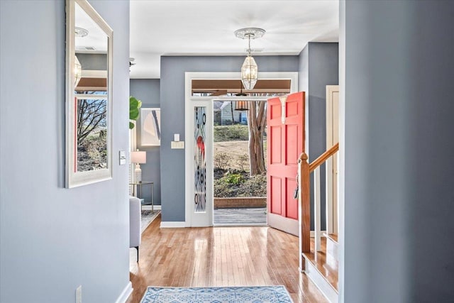 entrance foyer featuring a notable chandelier, wood finished floors, and baseboards