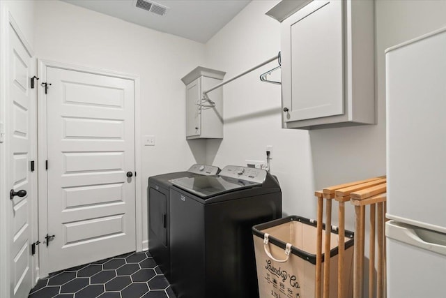 laundry area featuring visible vents, cabinet space, and washer and clothes dryer