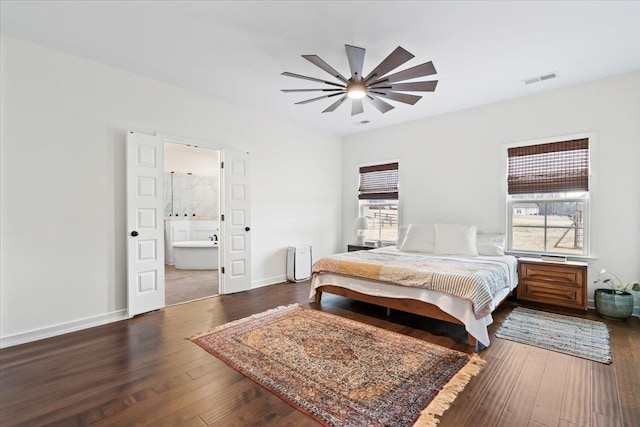 bedroom with visible vents, hardwood / wood-style floors, a ceiling fan, connected bathroom, and baseboards