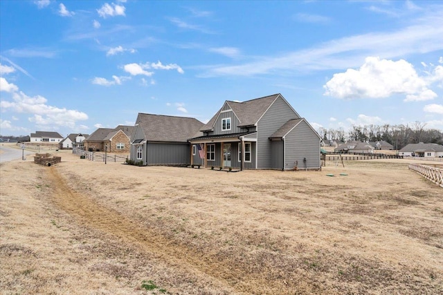 view of front facade featuring board and batten siding and fence