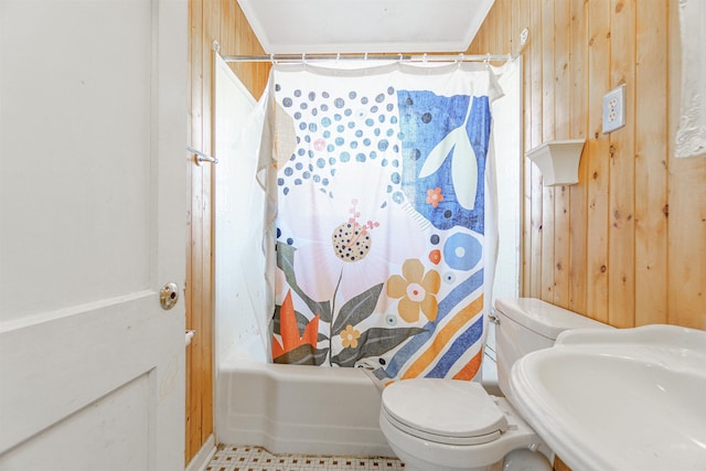 full bathroom with toilet, wood walls, a sink, and shower / tub combo with curtain