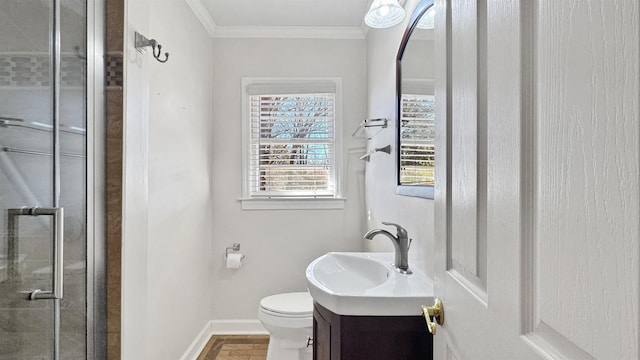 bathroom featuring a stall shower, baseboards, toilet, crown molding, and vanity