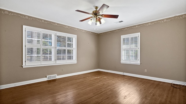 empty room with a ceiling fan, baseboards, visible vents, and wood finished floors