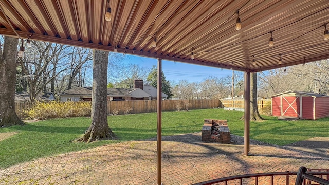 view of patio featuring a shed, a fenced backyard, and an outdoor structure