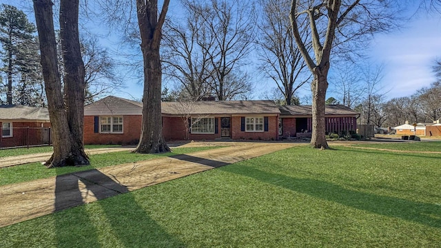 ranch-style home featuring brick siding, a front yard, and fence