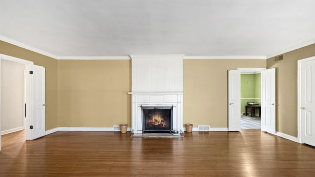 unfurnished living room featuring crown molding, visible vents, a fireplace, and wood finished floors