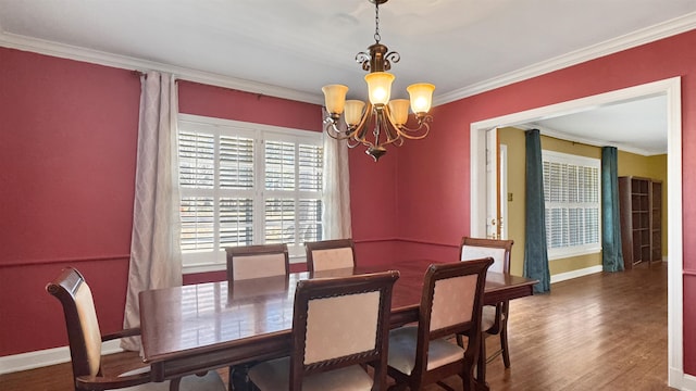 dining space featuring a notable chandelier, baseboards, crown molding, and wood finished floors