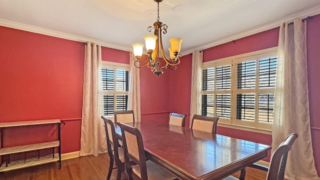 dining space with baseboards, crown molding, an inviting chandelier, and wood finished floors