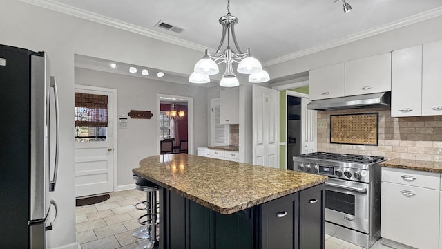 kitchen with a notable chandelier, tasteful backsplash, visible vents, appliances with stainless steel finishes, and under cabinet range hood