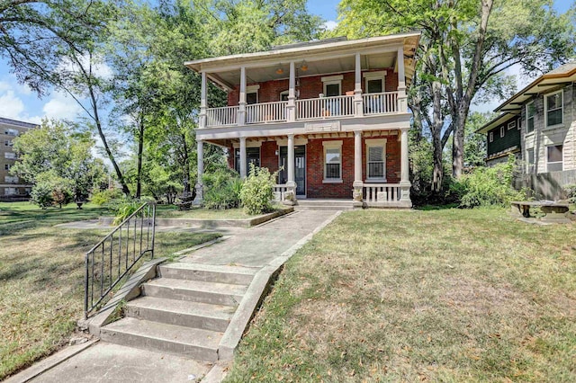 view of front of house with a porch, brick siding, a balcony, and a front lawn