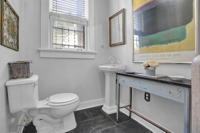 bathroom featuring tile patterned flooring, baseboards, and toilet