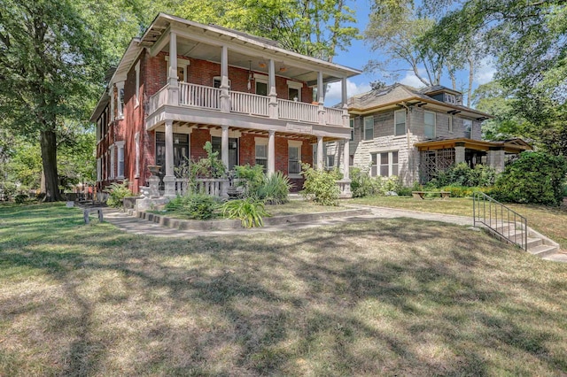 view of front of home with a balcony, a front yard, a porch, and brick siding