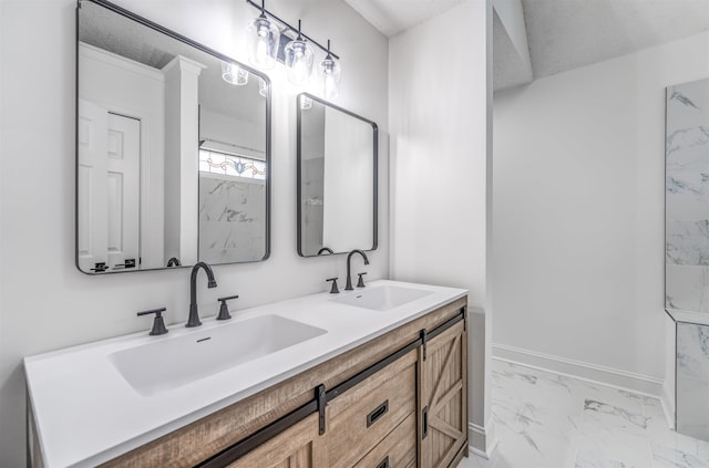 full bathroom featuring marble finish floor, double vanity, a sink, and baseboards