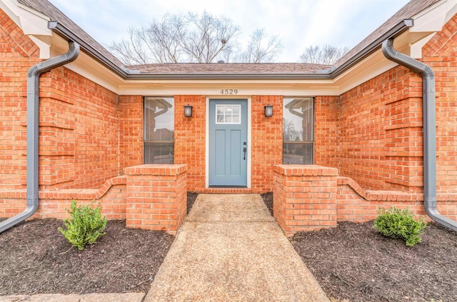 view of exterior entry with brick siding