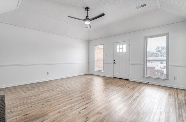 foyer entrance featuring visible vents, a ceiling fan, lofted ceiling, wood finished floors, and a textured ceiling