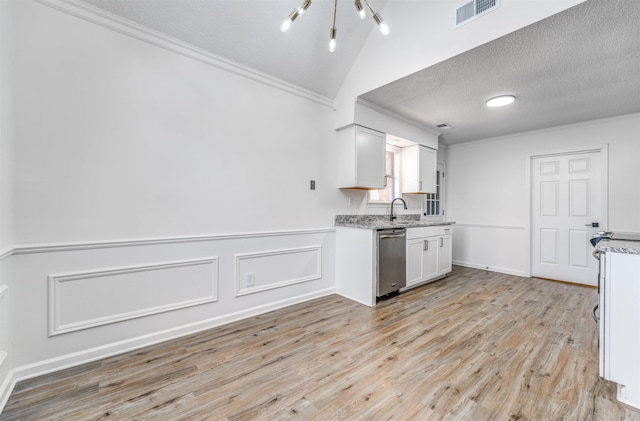 kitchen with dishwasher, a textured ceiling, visible vents, and crown molding