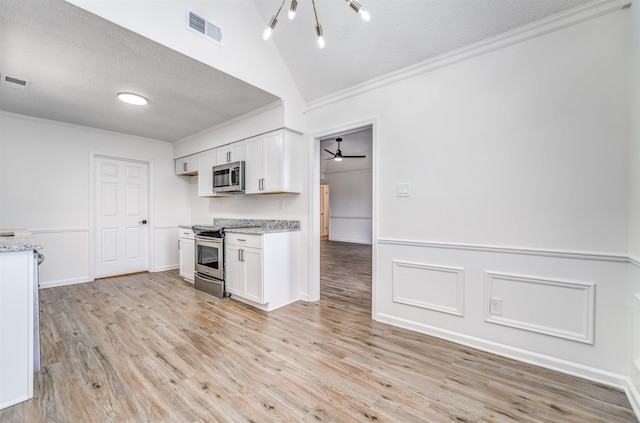 kitchen featuring visible vents, stainless steel appliances, a textured ceiling, crown molding, and white cabinetry