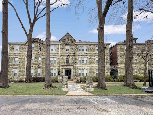 view of front of property with stone siding and a front lawn