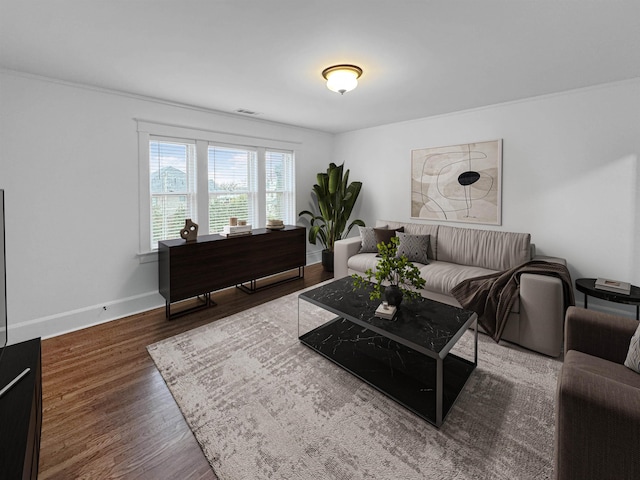 living room with visible vents, baseboards, and wood finished floors