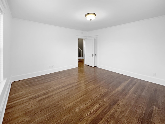 unfurnished room featuring baseboards and dark wood finished floors