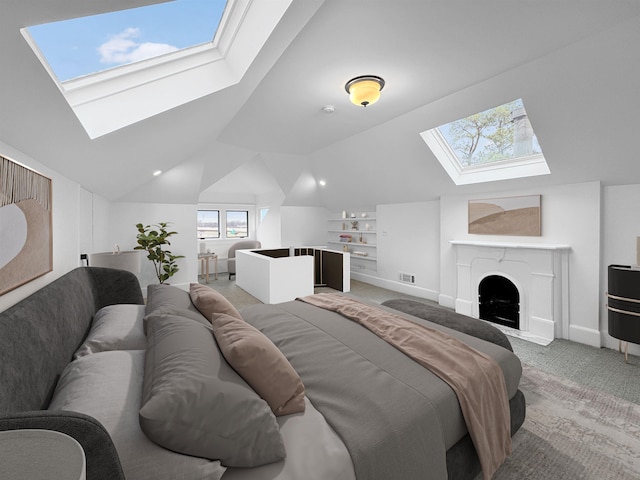 bedroom featuring lofted ceiling with skylight, light colored carpet, visible vents, and a fireplace with flush hearth