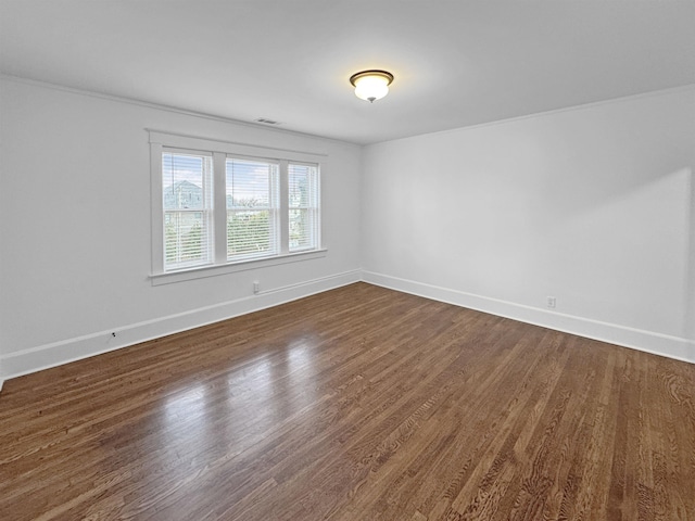 unfurnished room featuring visible vents, baseboards, and dark wood-style flooring