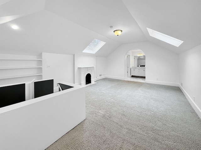 additional living space with carpet flooring, vaulted ceiling, and baseboards