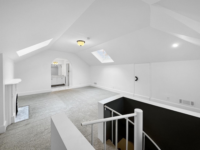 additional living space with lofted ceiling, carpet flooring, visible vents, and baseboards