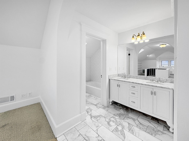 bathroom with double vanity, baseboards, lofted ceiling, marble finish floor, and a sink