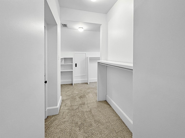 spacious closet with visible vents and light colored carpet