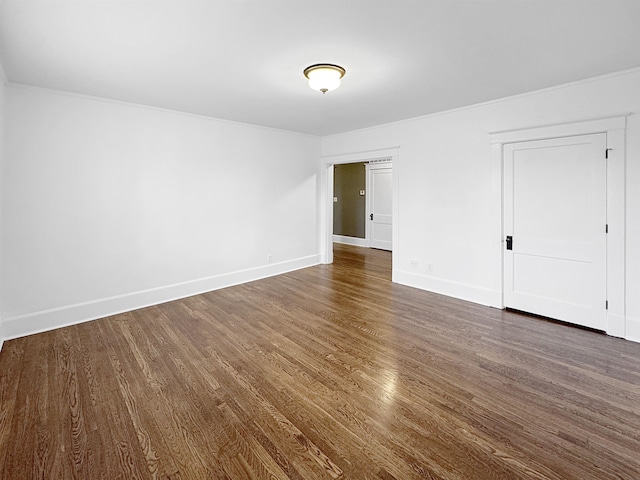 spare room with baseboards and dark wood finished floors