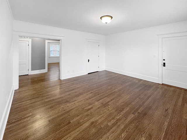 empty room with dark wood-type flooring and baseboards