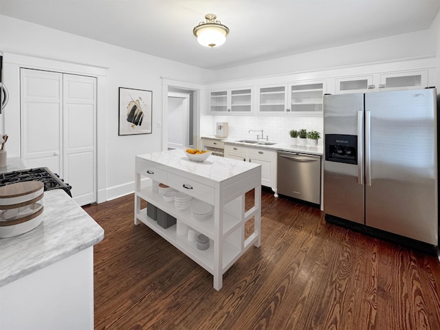 kitchen with dark wood finished floors, open shelves, appliances with stainless steel finishes, white cabinets, and a sink